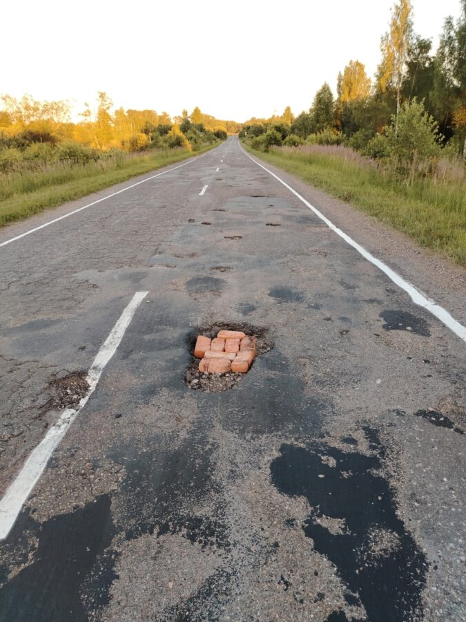Жители Тверской области с помощью кирпичей сами заделывают огромные ямы на дороге